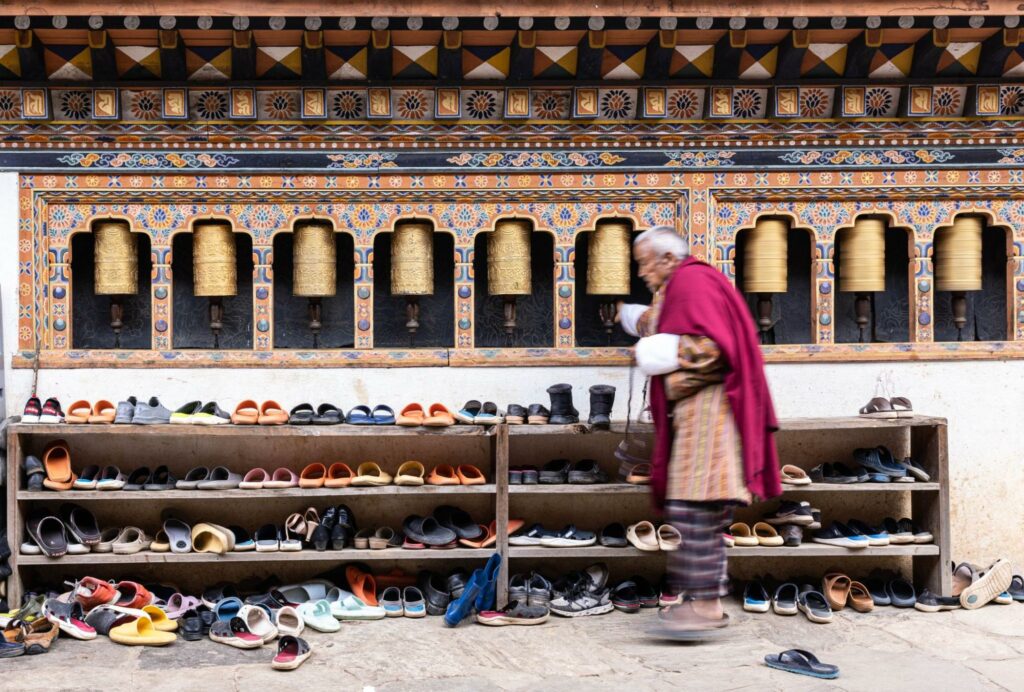 A Bhutanese man removing shoes before entering a building